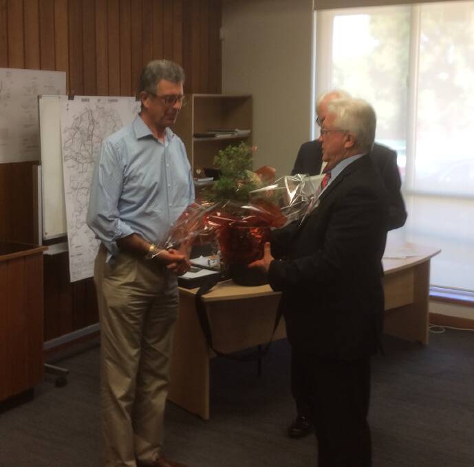 David Grant (left) is given his native plant by Harden Shire Acting General Manager Trevor Drowley and Mayor John Horton (right).