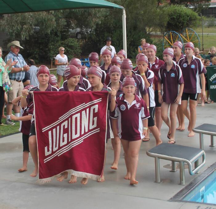 TEAM SPIRIT: Jugiong swimmers, in matching club shirts and caps, proudly march during the Shine Shield final round in Binalong on Saturday. The young swimmers won the march past competition. Picture: Jennette Lees 