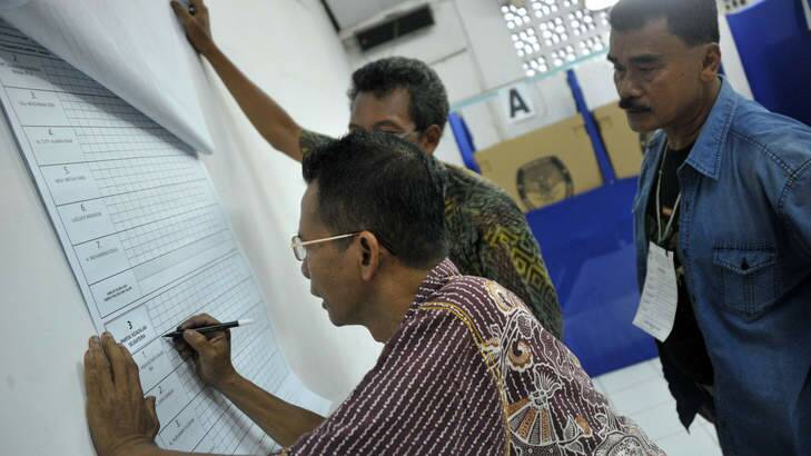 Election officials tally the vote count at a polling station in Jakarta on Wednesday. The result is likely to bring presidential candidate, Jakarta governor Joko Widodo, a step closer to becoming the country's next leader. Photo: AFP Photo