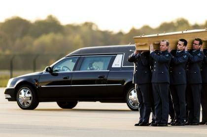 Dutch militarymen carry a coffin containing the remains of a victim of flight MH17 after a Hercules aircraft flying from Kharkiv, Ukraine, and transporting five coffins landed at Eindhoven airport on Saturday. Photo: Remko de Waal