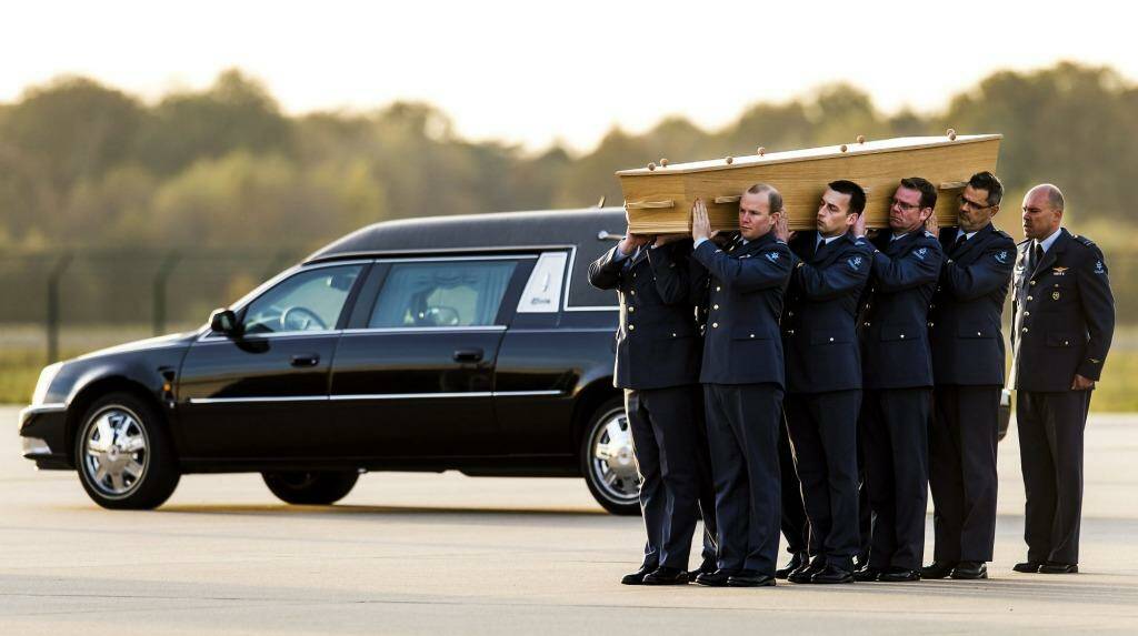 Dutch militarymen carry a coffin containing the remains of a victim of flight MH17 after a Hercules aircraft flying from Kharkiv, Ukraine, and transporting five coffins landed at Eindhoven airport on Saturday. Photo: Remko de Waal
