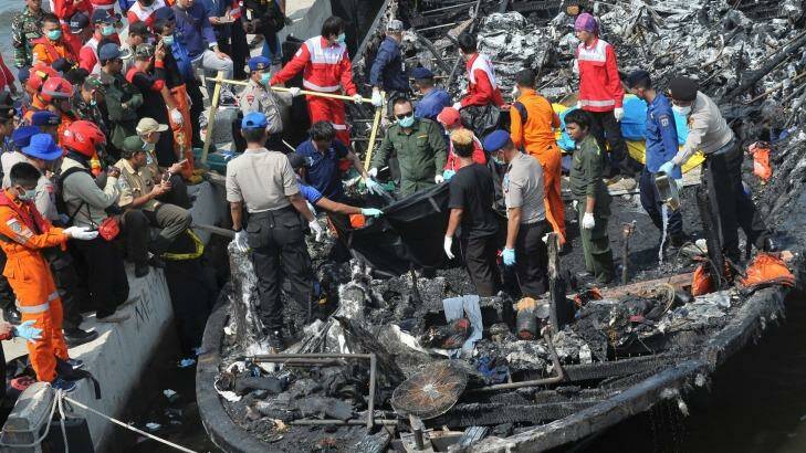 Rescuers search for victims from the wreckage of a ferry that caught fire off the coast of Jakarta. Photo: AP/Rhana Ananda