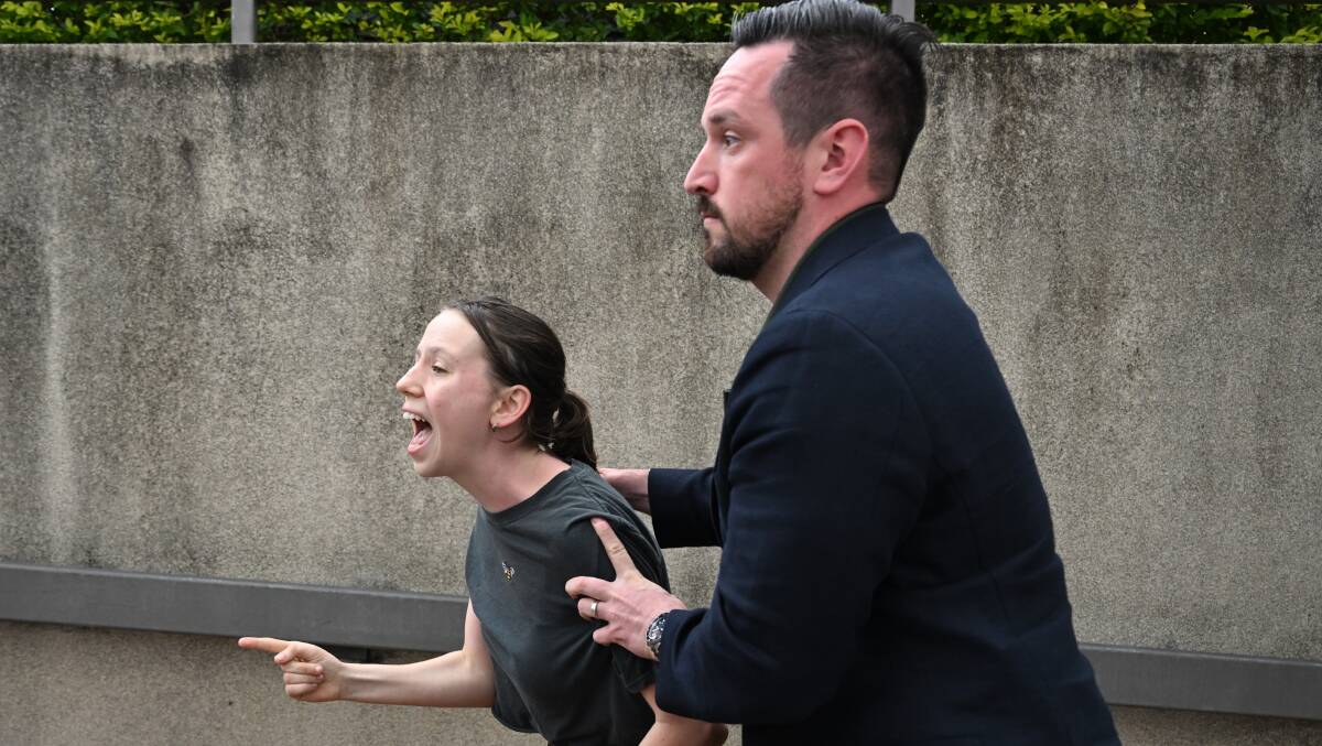 Rising Tide's Alexa Stuart is hauled away after interrupting Prime Minister Anthony Albanese's press conference in Sydney on Tuesday. Picture by AAP