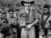An Australian member of the Royal Papua New Guinea Constabulary - called Kiaps - holds a baby in PNG in 1948. Picture AAP