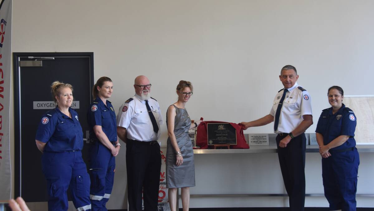 Ms Cooke and Mr Gibbs unveil the official plaque watched on by Harden Ambulance Station staff.