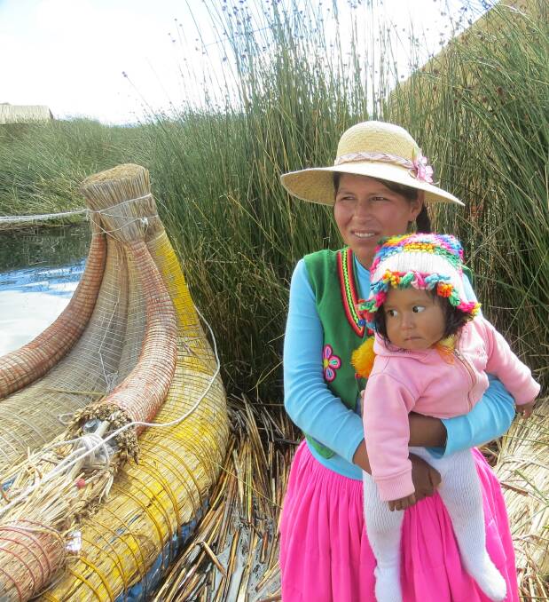 An Inca Indian woman and her child next to a reed boat on Lake Titicaca. Photo contributed by Ben and Irene Stocks.