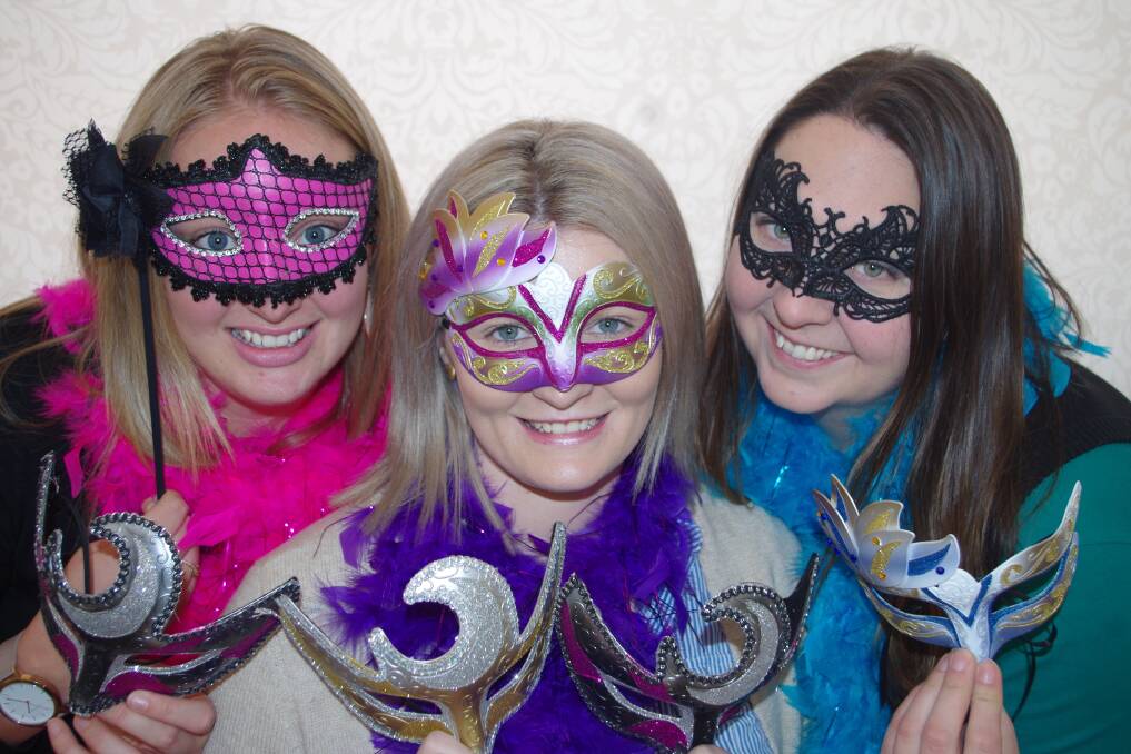 Samantha Harris, Natasha Battinich and Holly Bradford show some of the masks that will be available for purchase at the ball.