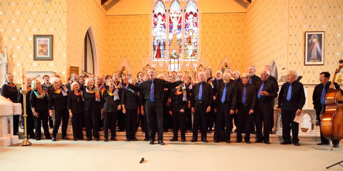 Musical Emeritus Brian Triglone (centre) leads the Canberra Gospel Folk Choir in one of its rollicking final numbers. Mr Triglone was making his final appearance with the choir in Sunday’s Boorowa concert. Photo: Supplied.