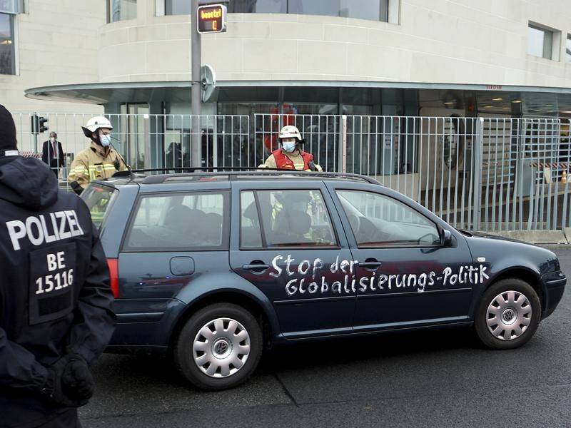 "Stop globalisation politics" was written on a car that hit a gate of Angela Merkel's offices.