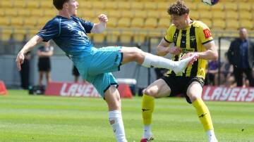 Newcastle goalscorer Clayton Taylor battles it out with Wellington's Lukas Kelly-Heald. Photo: Marty Melville/AAP PHOTOS