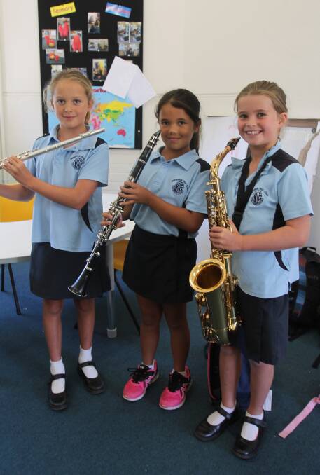 ASPIRING MUSICIANS: Year 3 students Hannah Guy, Pippa McKinley and Sybella Lenehan practise with the flute, clarinet and saxophone. Photo: Declan Rurenga